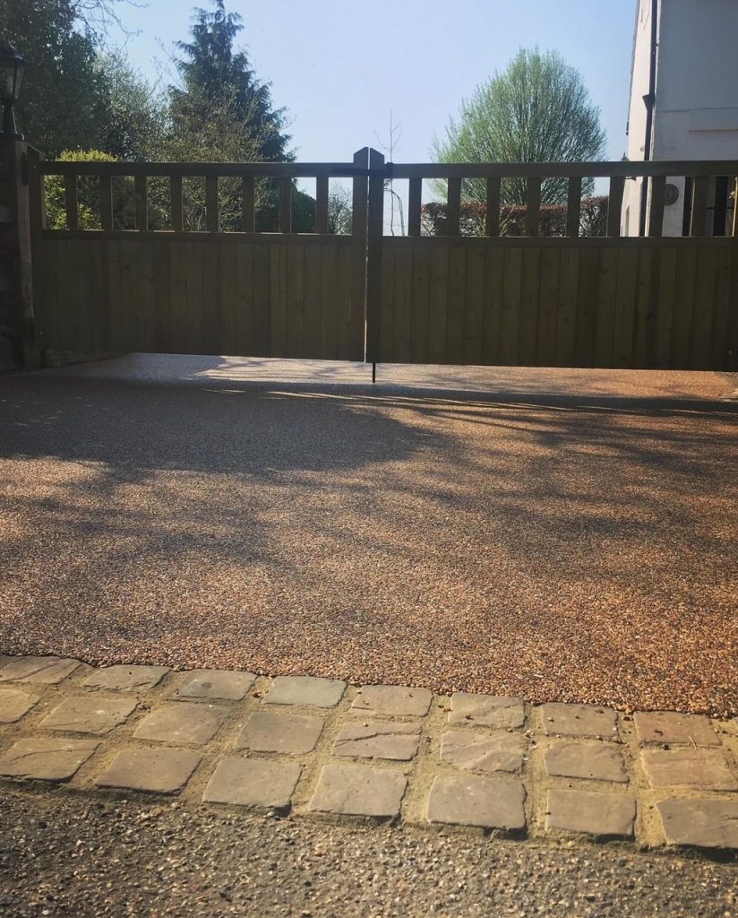 A resin driveway with cobble setts and a gate